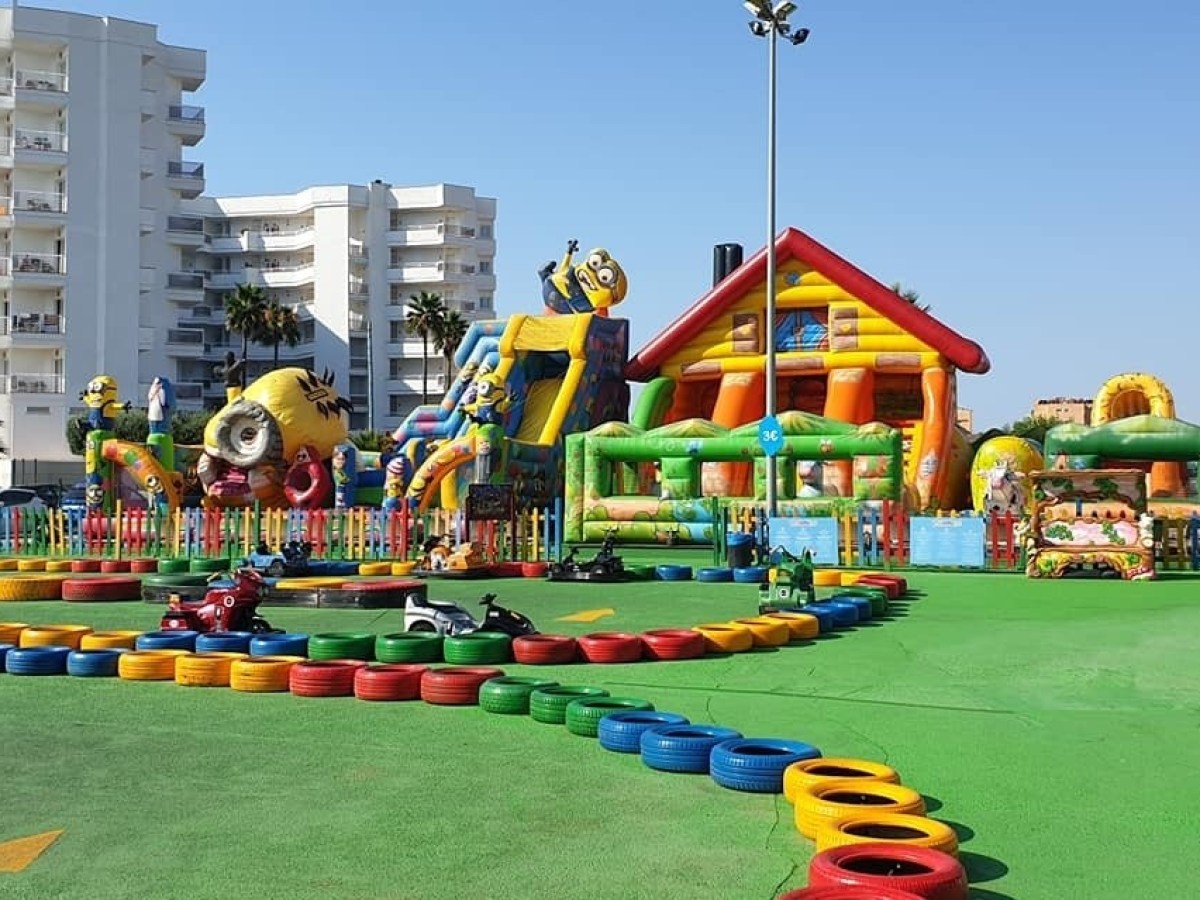a group of colorful inflatable bouncy castles next to a building