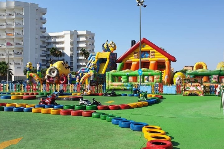 a group of colorful inflatable bouncy castles next to a building